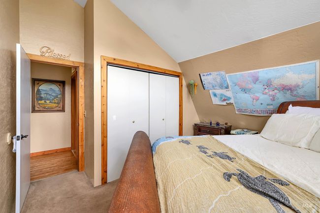 Bedroom featuring light colored carpet, lofted ceiling, and a closet | Image 37