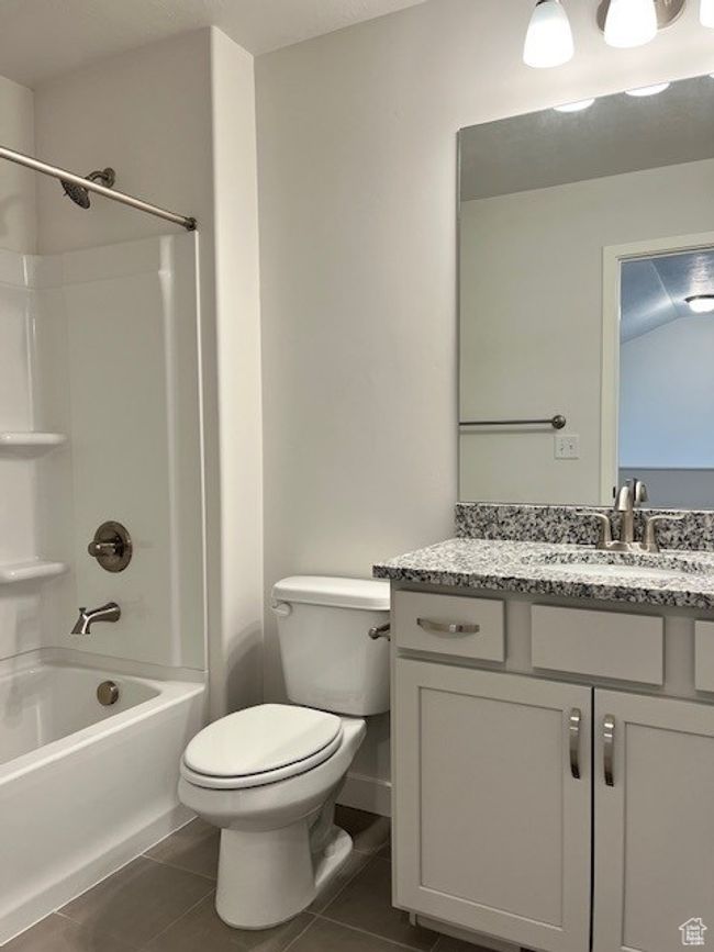 Full bath featuring tile patterned floors, toilet, bathing tub / shower combination, and vanity | Image 10
