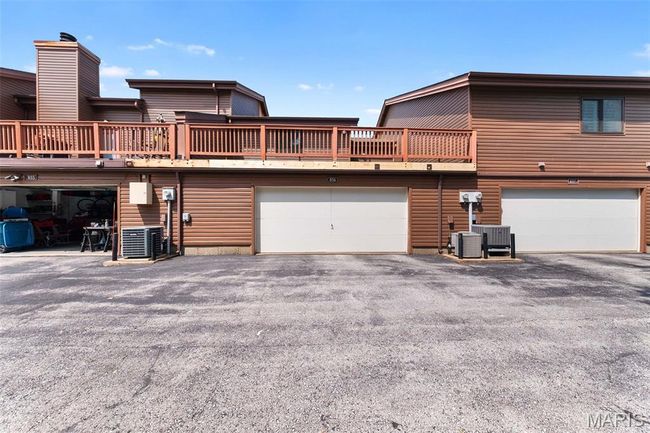 Rear view of unit with attached oversized 2 car garage, and a massive deck above. | Image 26
