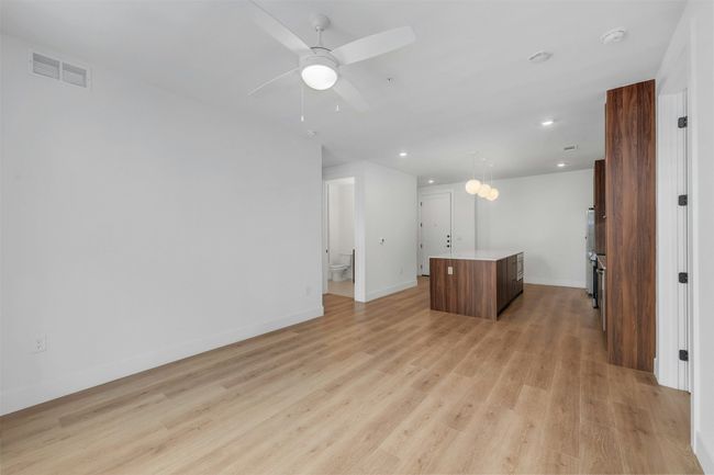 Unfurnished living room featuring light wood-style flooring, ceiling fan, and recessed lighting | Image 10