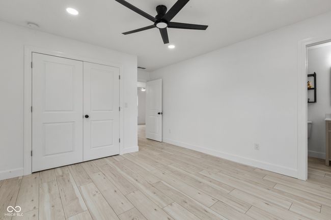 unfurnished bedroom featuring a closet, baseboards, light wood-type flooring, recessed lighting, and ensuite bath | Image 43