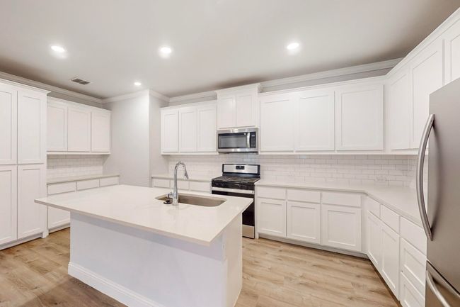 Kitchen with sink, white cabinets, and appliances with stainless steel finishes | Image 4