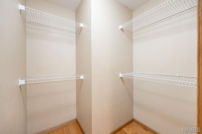 Walk in closet with light wood-style flooring | Image 27