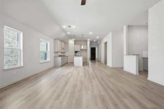 Unfurnished living room with light wood-type flooring, a ceiling fan, recessed lighting, and vaulted ceiling | Image 15