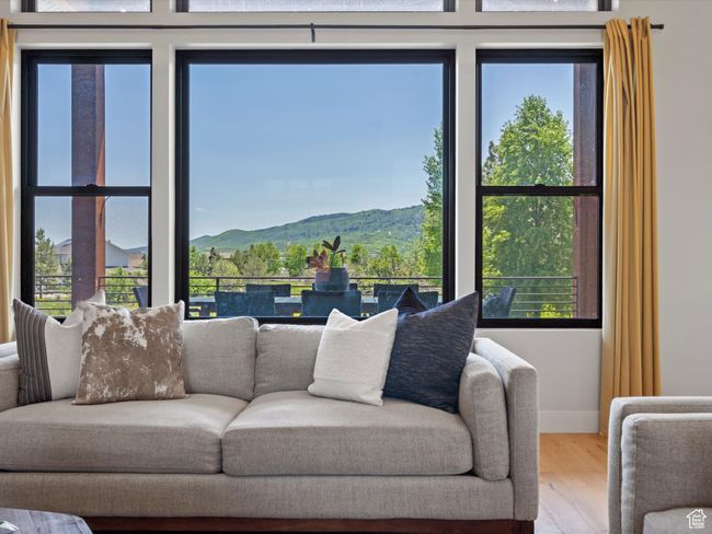 Living area featuring wood finished floors, a mountain view, and baseboards | Image 12