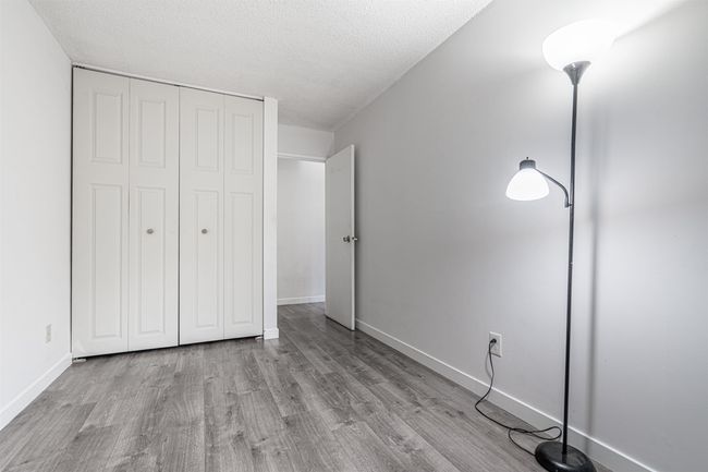 Unfurnished bedroom featuring a textured ceiling, wood finished floors, baseboards, and a closet | Image 14
