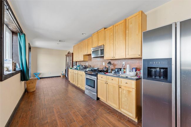 Kitchen with sink, appliances with stainless steel finishes, backsplash, dark hardwood / wood-style flooring, and light brown cabinets | Image 21