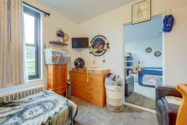 Carpeted bedroom featuring multiple windows and radiator | Image 7