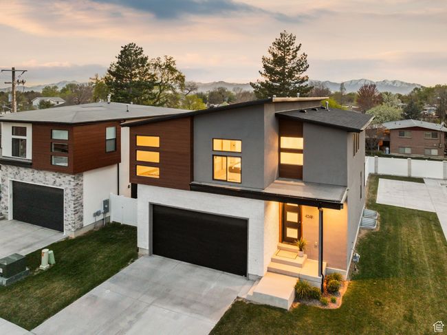 Contemporary home with an attached garage, a lawn, fence, and a mountain view | Image 43