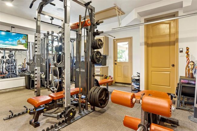 2 car garage is currently being used for a workout room but could be converted back. Owners have left the insulated garage door and rails. 40 gallon water heater was added above this space along with the 55 gallon thats in the house. | Image 32