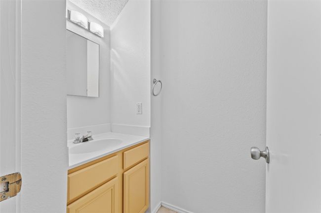 Bathroom featuring a textured ceiling and vanity | Image 11