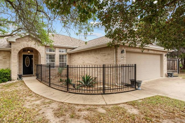 View of front facade with a shingled roof, driveway, fence private yard, brick siding, and a garage | Image 14