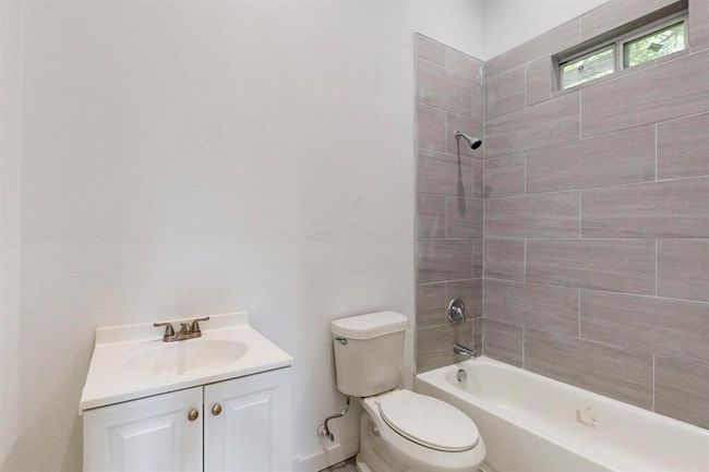 Full bathroom featuring tiled shower / bath, toilet, and vanity | Image 16