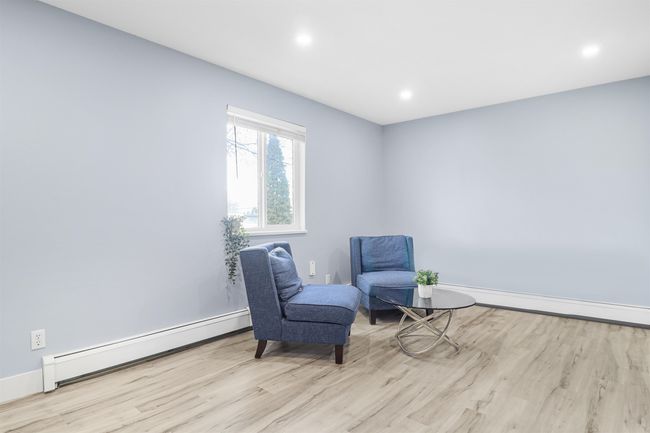 Living area with wood finished floors, a baseboard radiator, baseboard heating, baseboards, and recessed lighting | Image 10