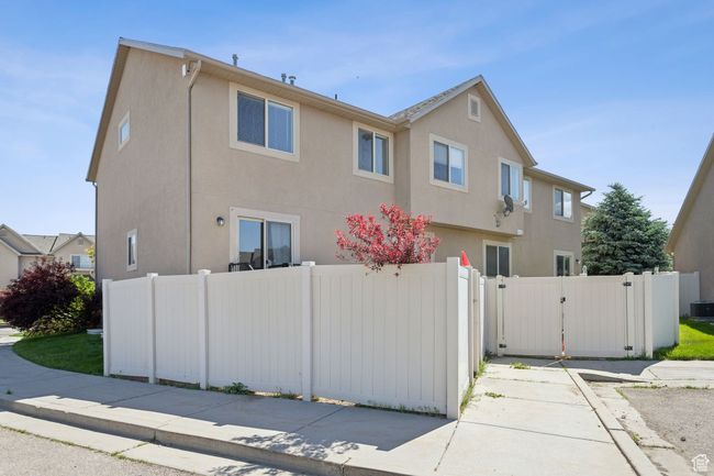 View of side of home with a gate, stucco siding, and central AC unit | Image 25