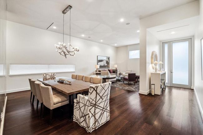View of the FRONT HALL opening to the LIVING ROOM (18 X 16) and DINING ROOM (16 X 16) - all appointed with the 12 foot ceiling height, recessed lighting, painted walls, dramatic horizontal accented windows and gleaming hardwood flooring. A grand and impressive entertaining space. | Image 4
