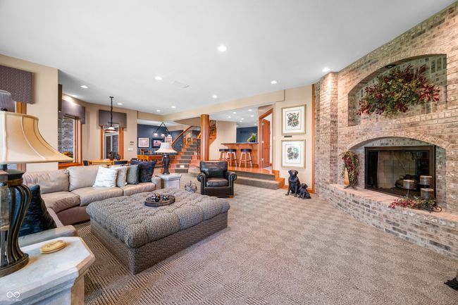 carpeted living room featuring a brick fireplace, recessed lighting, and stairs | Image 70
