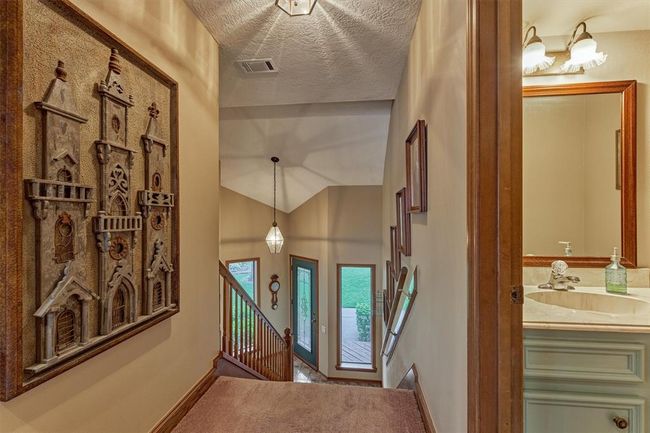 Looking down from the top level, you’ll see the front entry and a well-placed half bath on the right, perfect for guests. | Image 24