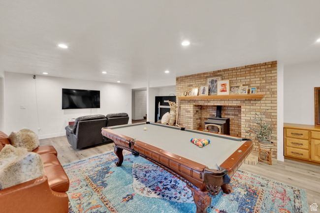 Playroom featuring light wood-style flooring, billiards table, recessed lighting, and a wood stove | Image 28