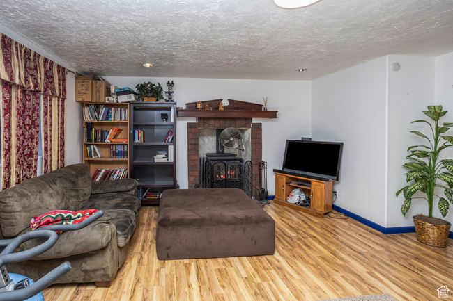 Living room with a textured ceiling, wood finished floors, and baseboards | Image 14