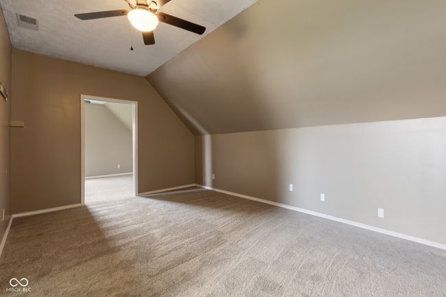 additional living space with baseboards, vaulted ceiling, carpet floors, visible vents, and ceiling fan | Image 23