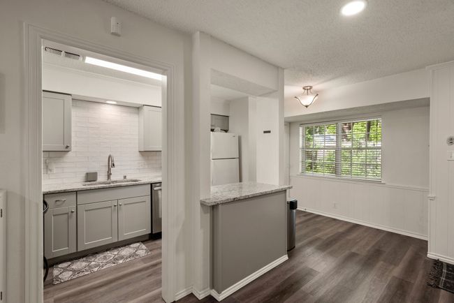 Kitchen featuring a textured ceiling, freestanding refrigerator, a sink, and dark wood-type flooring | Image 7