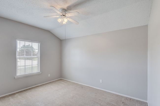 Spare room with carpet flooring, a ceiling fan, a textured ceiling, baseboards, and vaulted ceiling | Image 22