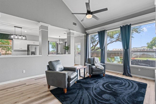 Living area features ceiling fan, vaulted ceiling, and built-ins. | Image 7