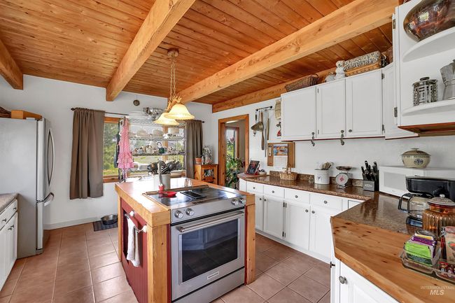 Kitchen with butcher block counters, appliances with stainless steel finishes, healthy amount of natural light, and a wood ceiling with exposed beams | Image 20