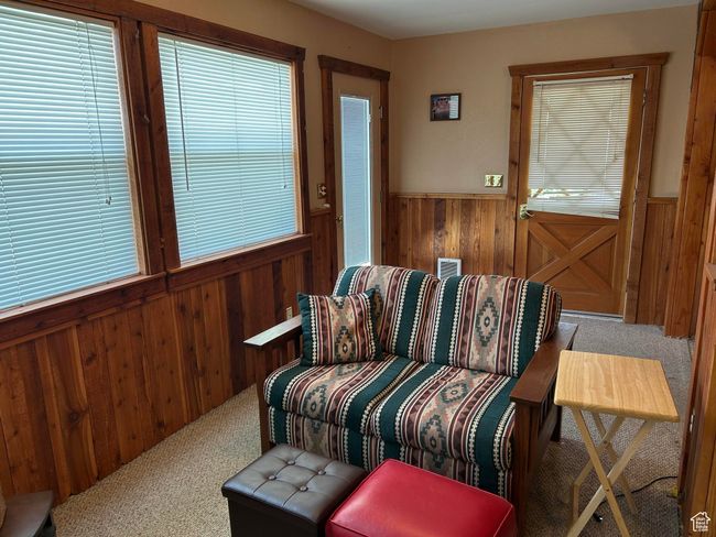 Living area featuring carpet, wooden walls, and wainscoting | Image 17