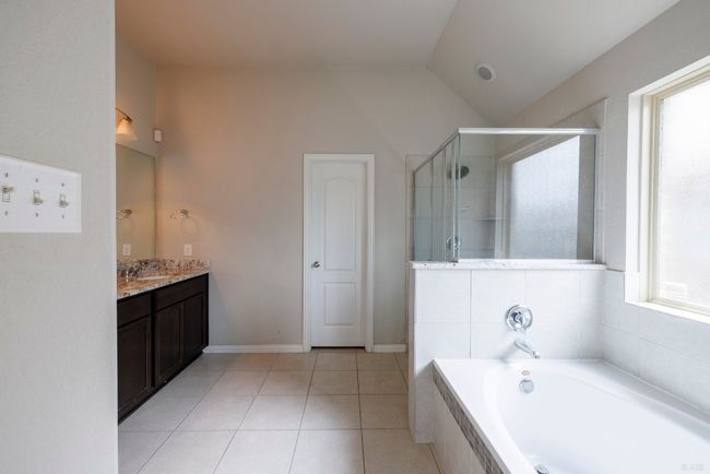Full bathroom featuring vanity, a bath, vaulted ceiling, a shower stall, and tile patterned flooring | Image 12