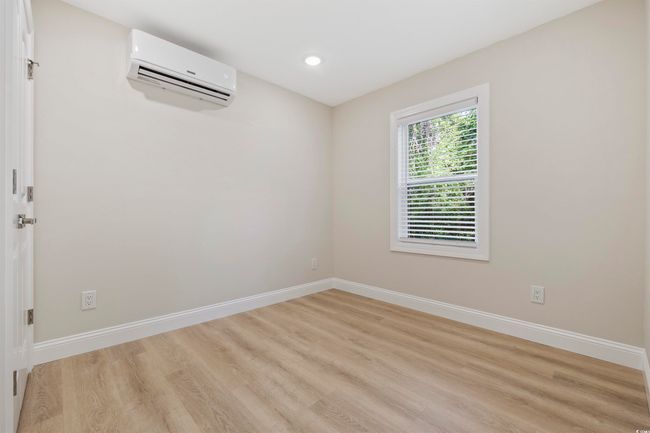 Spare room featuring a wall unit AC, light wood-type flooring, baseboards, and recessed lighting | Image 25