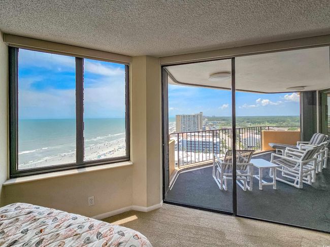 Carpeted bedroom featuring access to outside, multiple windows, a textured ceiling, and a water view | Image 29