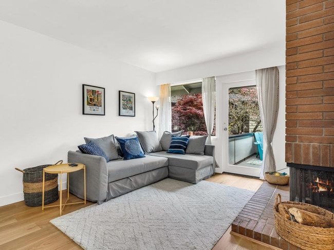 Living area with wood finished floors and a fireplace | Image 12
