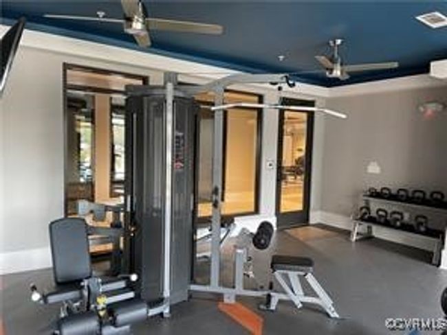 Exercise area featuring baseboards, a ceiling fan, and visible vents | Image 10