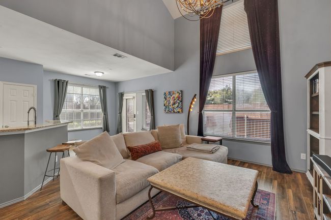 Living room with a high ceiling, a chandelier, and dark wood-style flooring | Image 17