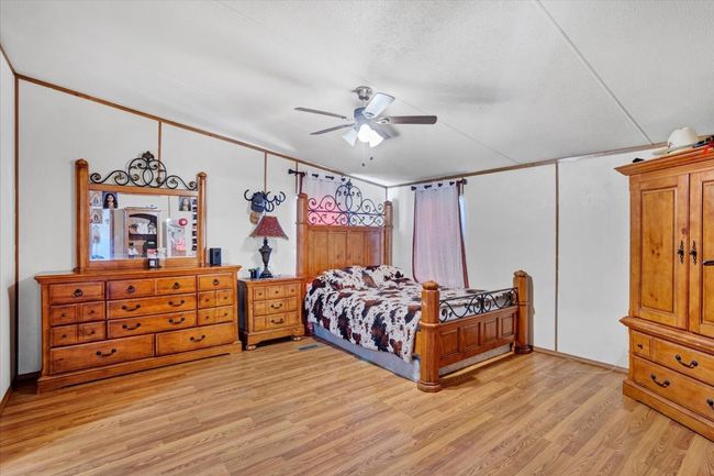 Bedroom featuring light wood-type flooring, ceiling fan, and a textured ceiling | Image 12