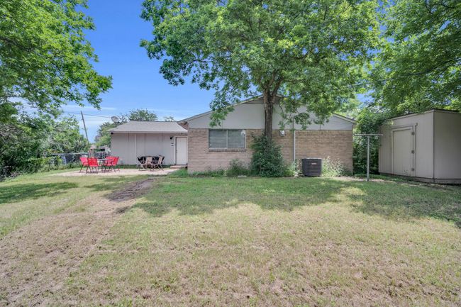 Back of property with brick siding, a storage unit, central AC unit, and a yard | Image 31