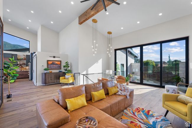 Living area with high vaulted ceiling, light wood-style flooring, a ceiling fan, healthy amount of natural light, and beam ceiling | Image 12