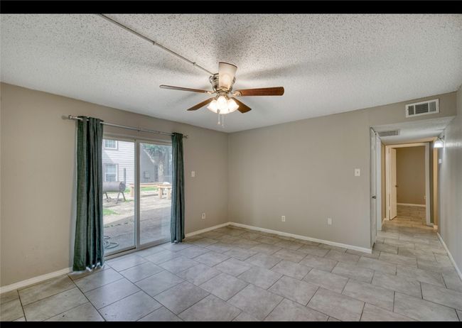 Spare room featuring a ceiling fan, a textured ceiling, and light tile patterned flooring | Image 13
