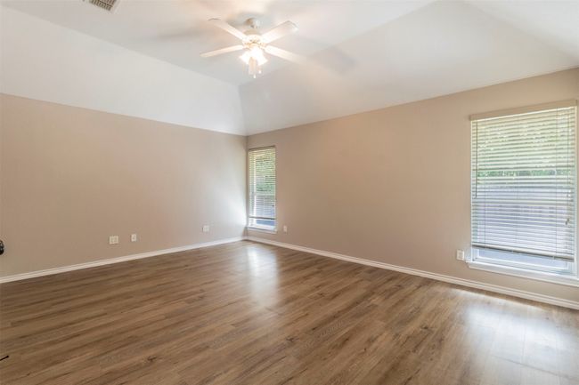 Unfurnished room featuring lofted ceiling, baseboards, a ceiling fan, and wood finished floors | Image 19