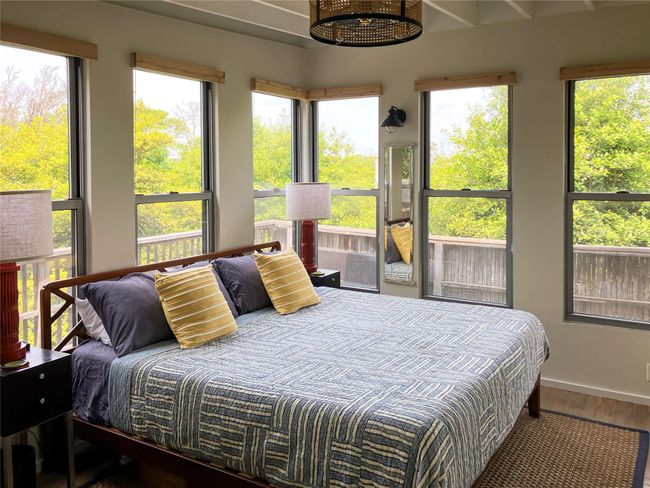 Bedroom with wood finished floors and multiple windows | Image 10