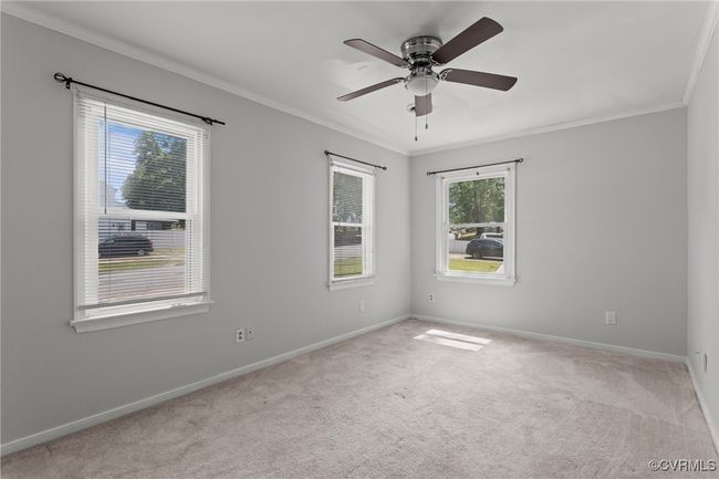 Carpeted spare room with a ceiling fan, baseboards, and ornamental molding | Image 29