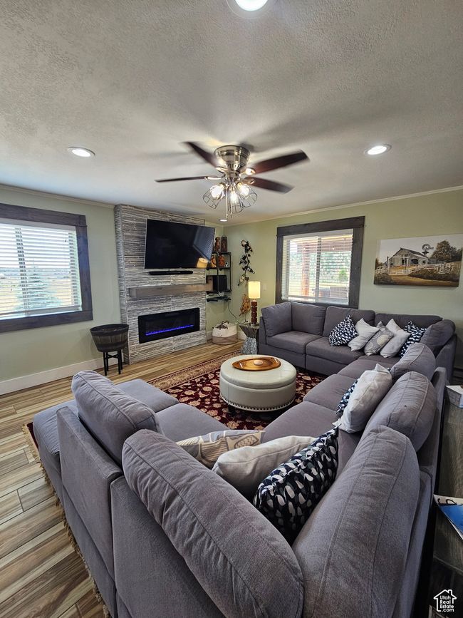 Living room with a ceiling fan & stone glass fireplace | Image 28