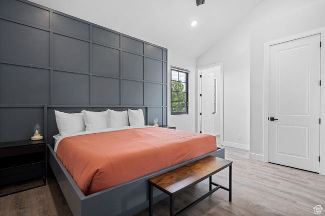 Bedroom with high vaulted ceiling and light wood-type flooring | Image 14