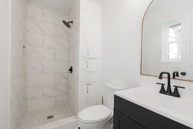 Bathroom featuring vanity and tiled shower | Image 21