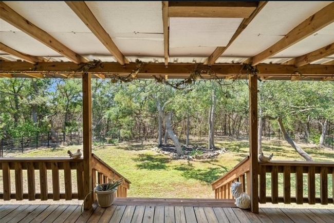 Deck featuring view of fenced, treed yard | Image 14
