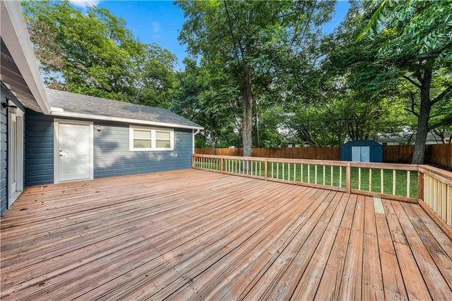 This deck will be removed and rebuilt as either a concrete patio or raised redwood deck stained to match the fence. | Image 37