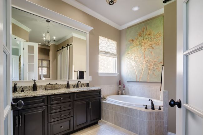 The primary bathroom includes double vanities, separate tub, and shower. | Image 35