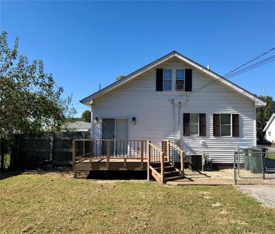 Rear view of house with a wooden deck and a yard | Image 2